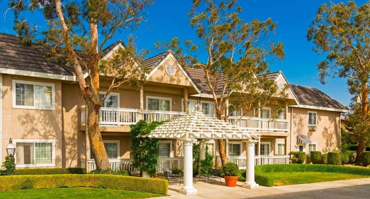 Front view of Sterling Inn with landscaped gardens and a pergola.