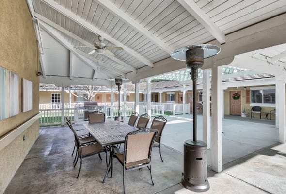 Covered outdoor seating area with table and chairs