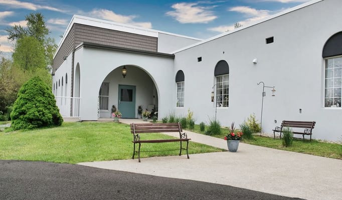 Exterior view of Sunrise Manor with garden and benches