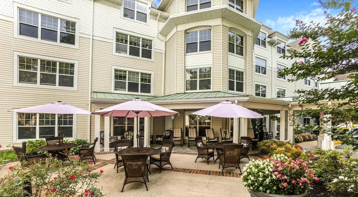Outdoor patio with tables and umbrellas at Sunrise at Bluemont Park.