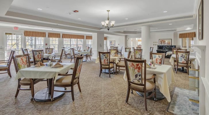 Brightly lit dining room with tables set for meals