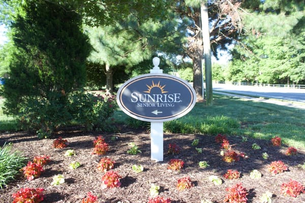 Sign for Sunrise Senior Living surrounded by flowers