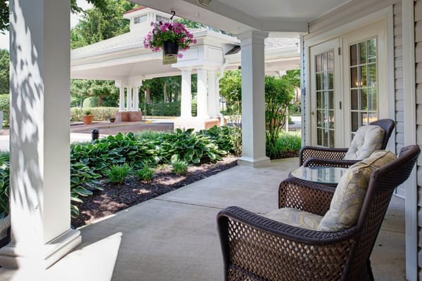 Cozy seating area on the porch surrounded by greenery.
