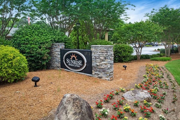 Sign for Sunrise Senior Living surrounded by landscaping