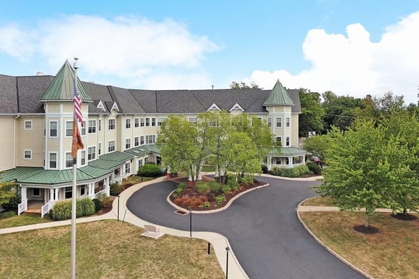 Aerial view of the exterior of Sunrise of Abington senior living facility with trees and pathways.