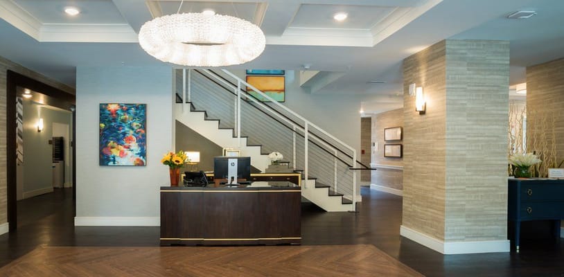 Modern reception area with a large chandelier and floral decor