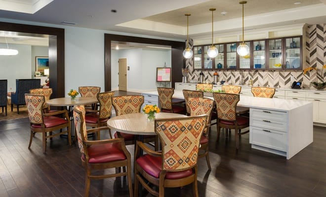 Bright and inviting common area with dining tables and decorative chairs