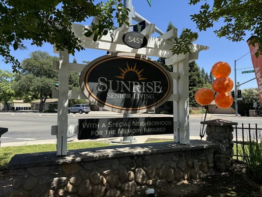 Sign for Sunrise Senior Living with orange balloons
