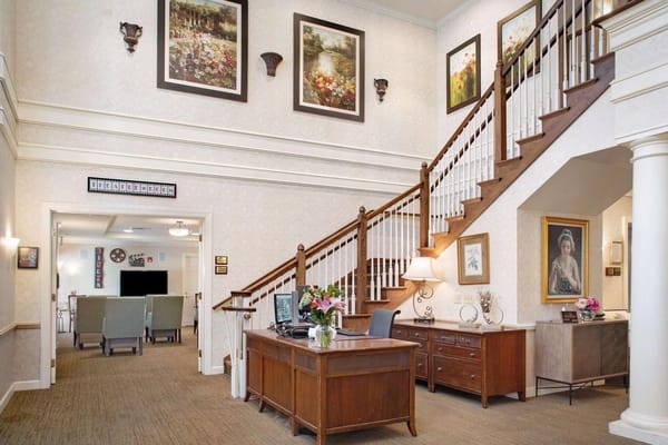 Spacious lobby with a staircase and decorative wall art.