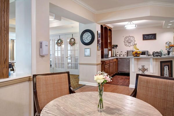 Common area with a table, flowers, and a refreshment station.