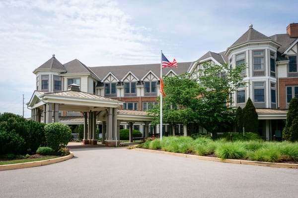 Exterior view of a senior living facility entrance with flags
