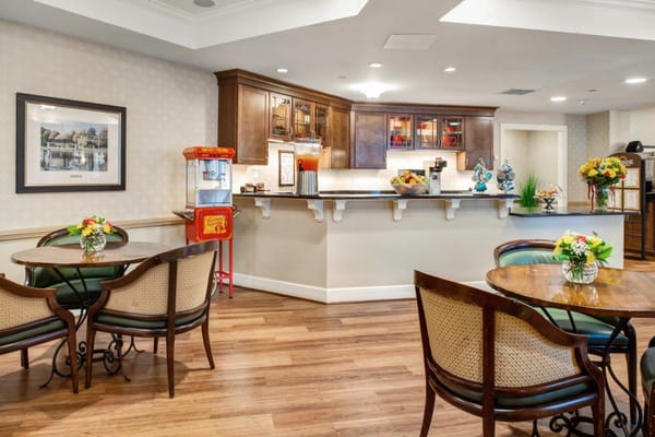 Cozy common area with tables, flowers, and a popcorn machine.
