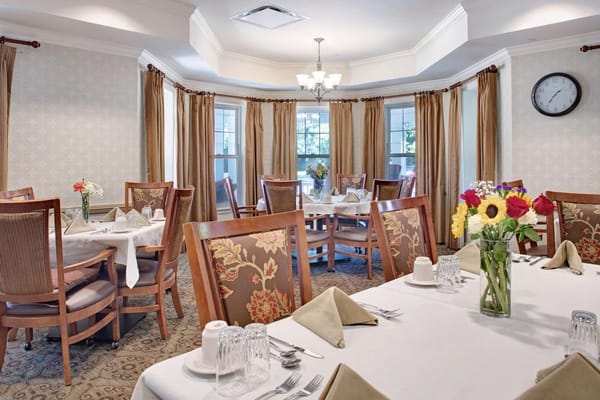 Elegant dining room set up with tables and flowers.