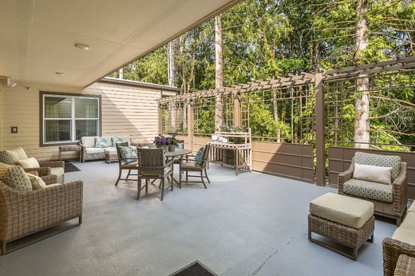 Outdoor patio with seating and greenery at Sunrise of Issaquah.