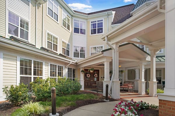 Welcoming entrance with seating and flowerbeds at Sunrise of Lafayette Hill.