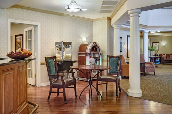 A cozy lounge area with a small table, chairs, and a jukebox.