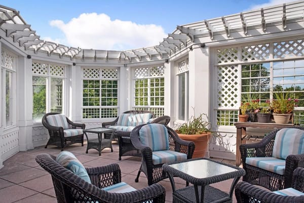 Bright sunroom with wicker furniture and potted plants