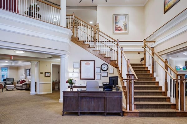 Welcoming lobby with a reception desk and staircase.