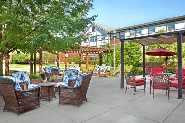 Comfortable outdoor seating area with floral cushions and shaded dining space.