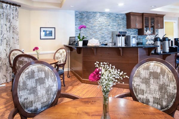 Cozy common area with wooden tables and floral decorations.