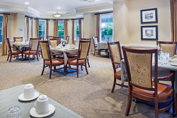 Brightly lit dining room with tables and chairs set for dining