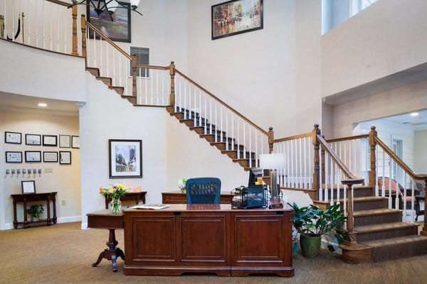 Spacious reception area featuring a wooden desk and staircase.