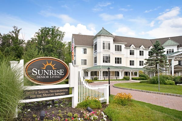 Exterior view of Sunrise Senior Living facility with sign