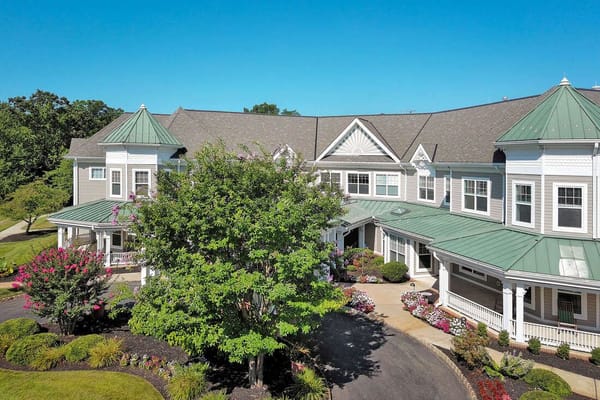Aerial view of the exterior entrance of Sunrise of Wall with lush landscaping.