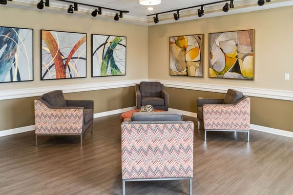 A cozy living area with modern furniture and colorful artwork on the walls.