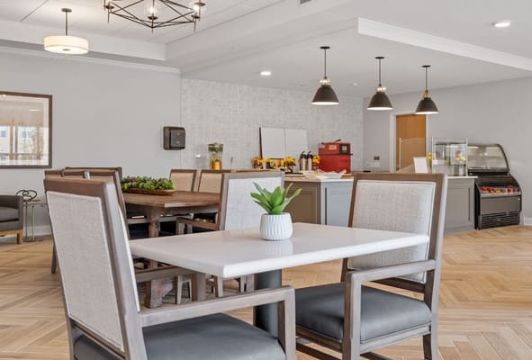 Bright and inviting common area with dining tables and kitchen amenities