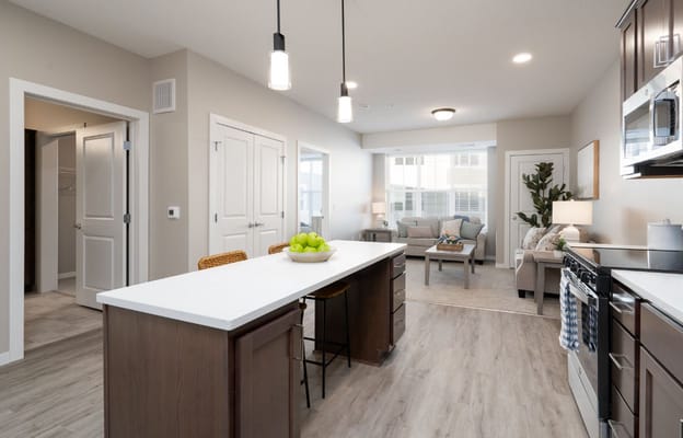 Bright kitchen with an open living area featuring a cozy sofa and dining space.
