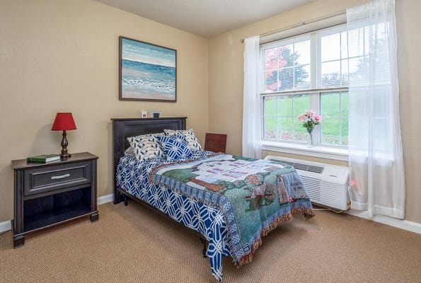 Bright and inviting bedroom with a bed, nightstand, and window.