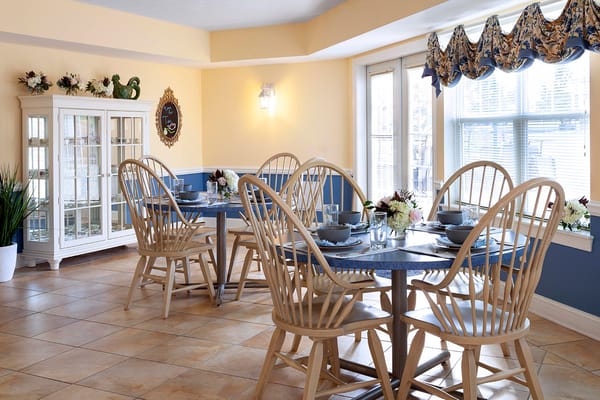 Brightly lit dining room with wooden tables and chairs