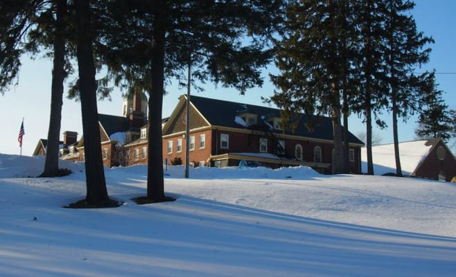 Snow-covered exterior of The Berkeley Retirement Home surrounded by trees