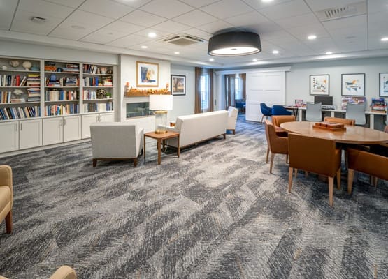 Lounge area with bookshelves, seating, and a fireplace