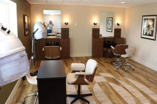 Interior view of the salon with styling chairs and hairdryers.