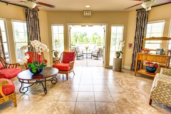 Inviting lobby with red chairs and a view to the outdoor seating area