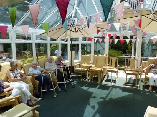 Bright social area with residents seated and colorful bunting