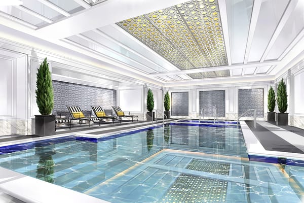 Elegant indoor pool area with lounge chairs and decorative tiles.