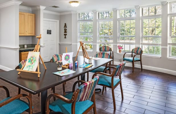 Sunny art room featuring easels and colorful chairs