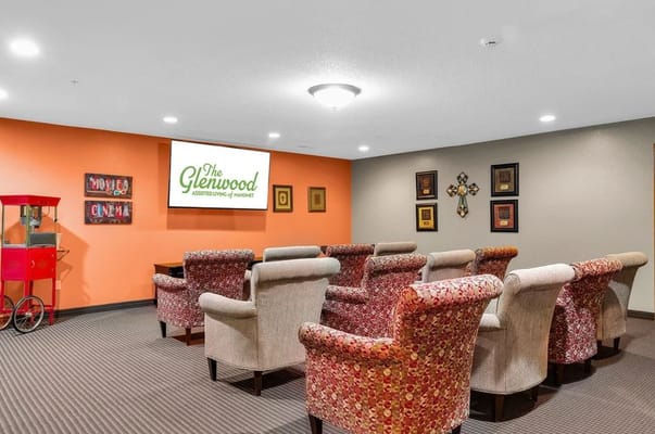 Common area with seating and facility logo on screen