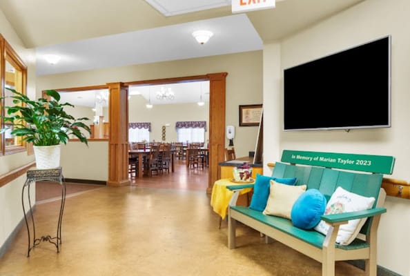 Cozy lobby with green bench and decorative pillows at The Glenwood Assisted Living.