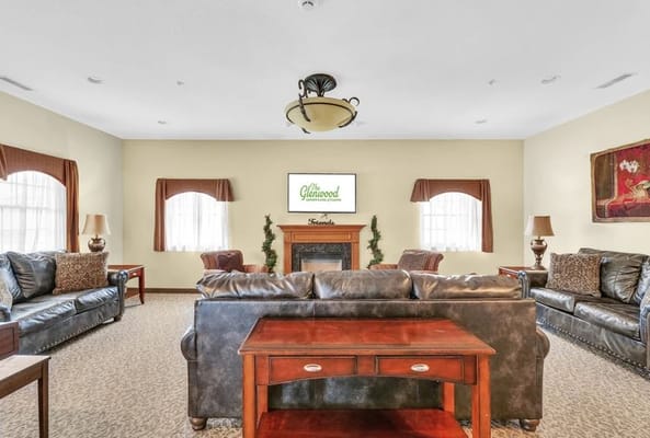Lounge area with sofas and a fireplace at The Glenwood Supportive Living