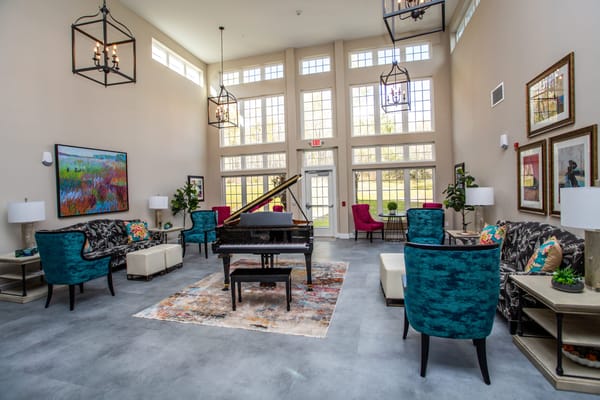 Cozy lounge area featuring a grand piano and colorful seating in The Grand Hills Castle