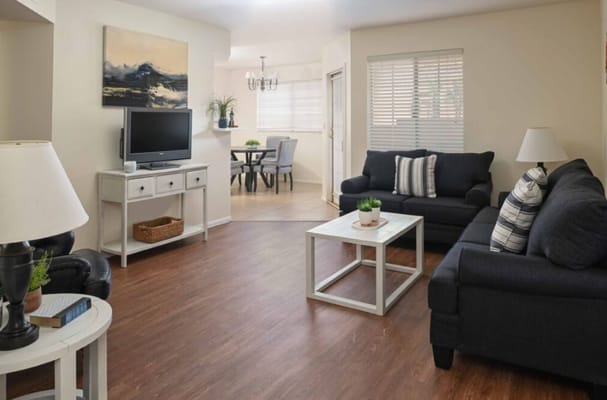 Bright living room with black sofas and a table