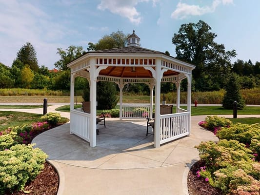 White gazebo surrounded by colorful flowers