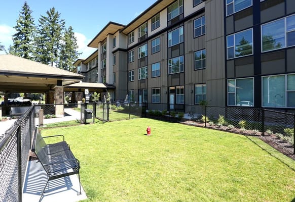 View of the exterior of The Lofts by Cogir with landscaping and seating area
