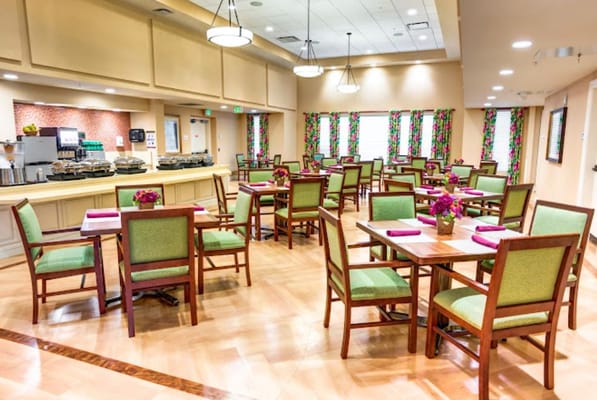 Bright and inviting dining area with green chairs and floral decorations