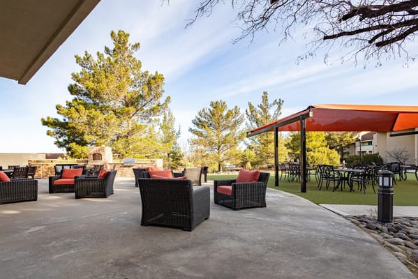 Patio seating with wicker chairs and orange cushions at MonteVista.