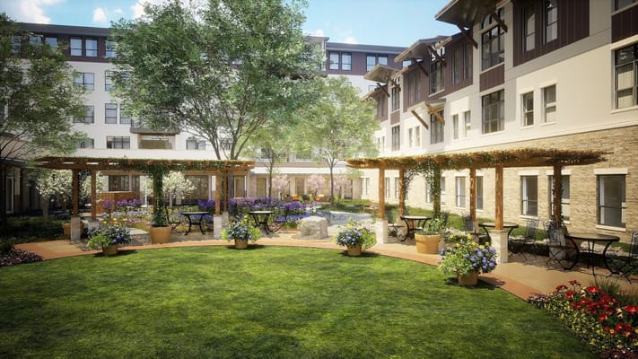 A beautifully landscaped courtyard with seating and flower pots.